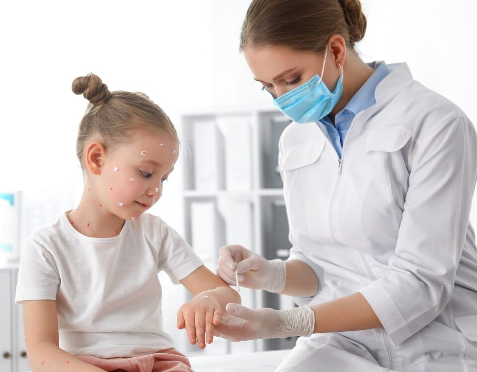 Doctor Applying Cream Onto Skin Of Little Girl With Chickenpox